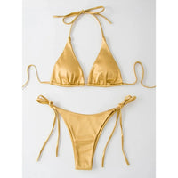 Bikini brésilien satiné triangle tour de cou doré posé à plat sur fond blanc, liens latéraux longs
