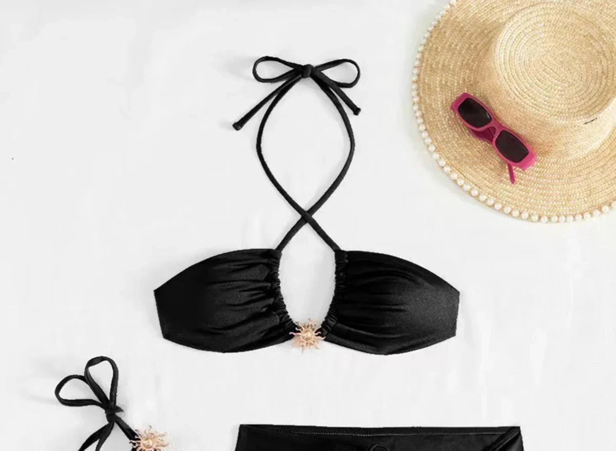 Gros plan sur le haut du maillot trois pièces avec jupe portefeuille et haut halter noir