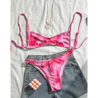 Bikini triangle échancré imprimé fleuri rose posé à plat, haut à bonnets en doublure blanche et bas fleuri