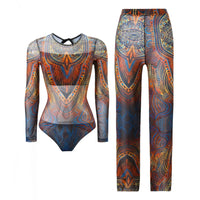 Maillot de bain une pièce manches longues et pantalon bleu à motifs orange posé à plat sur fond blanc, ensemble complet