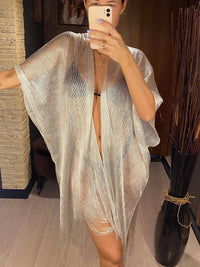 Tunique de plage à franges en maille brillante argentée portée de face en selfie miroir, manches amples et franges au bas