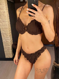 Bikini brésilien triangle effet froissé à volants marron porté de face par une femme qui se photographie dans un miroir