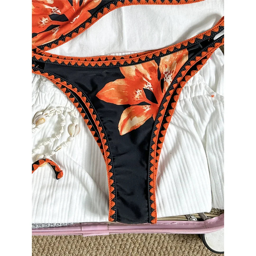 Bikini brésilien triangle imprimé fleuri noir et orange, gros plan sur la culotte et les fleurs orange sur fond noir