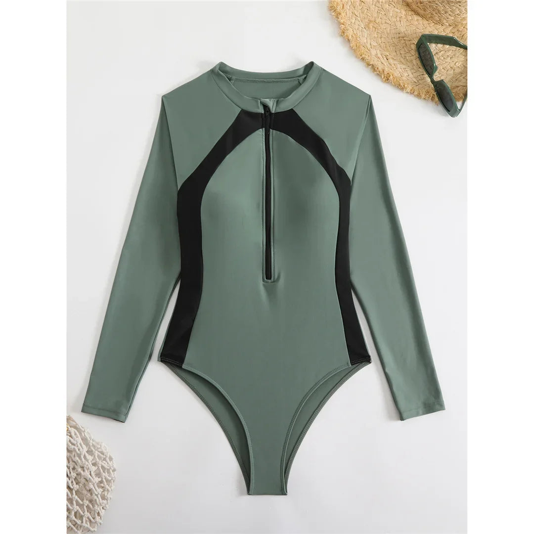 Maillot une pièce vert foncé à manches longues et zip au col, empiècements noirs sur les côtés, posé à plat