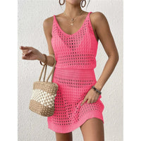 Tunique de plage en crochet ajourée rose fuchsia portée de face, avec un sac en paille tressé