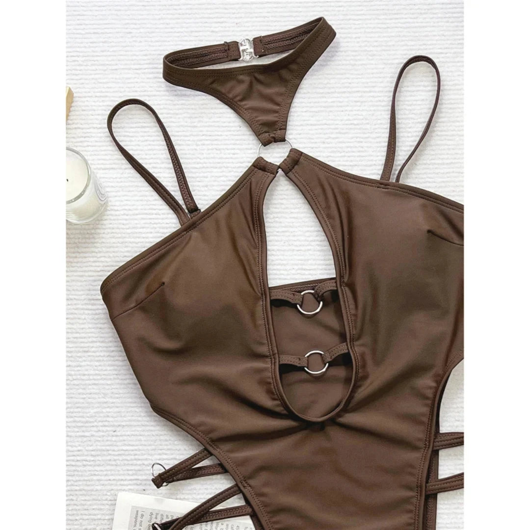 Gros plan sur le décolleté échancré marron café d'un maillot une pièce, deux anneaux métalliques et lanières latérales