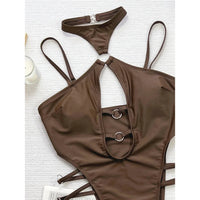 Gros plan sur le décolleté échancré marron café d'un maillot une pièce, deux anneaux métalliques et lanières latérales