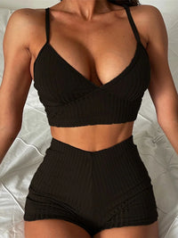 Bikini côtelé taille haute avec bas short noir porté de face en gros plan sur un lit blanc, col V et bretelles fines