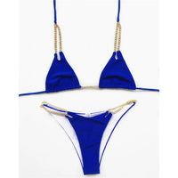 Bikini tour de cou à chaîne métallique bleu foncé posé à plat sur fond blanc, chaînes dorées sur la culotte