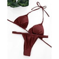 Bikini string triangle froncé marron café posé à plat sur un fond blanc avec feuillage, liens longs