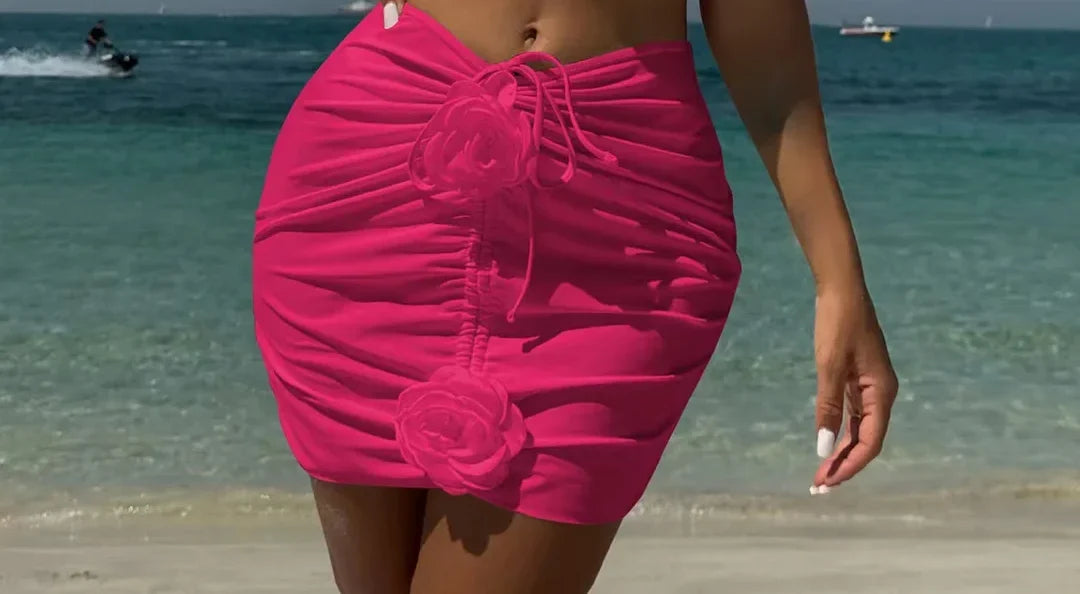 Gros plan sur le bas du trikini avec jupe froncée et fleurs en relief rose fuchsia