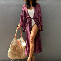 Tunique de plage imprimée manches longues à ceinture rose fuchsia portée de face avec un chapeau de paille et sac en osier