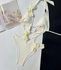 Maillot une pièce blanc cassé à décolleté plongeant orné de fleurs 3D et de bijoux, vue à plat avec bretelles nouées