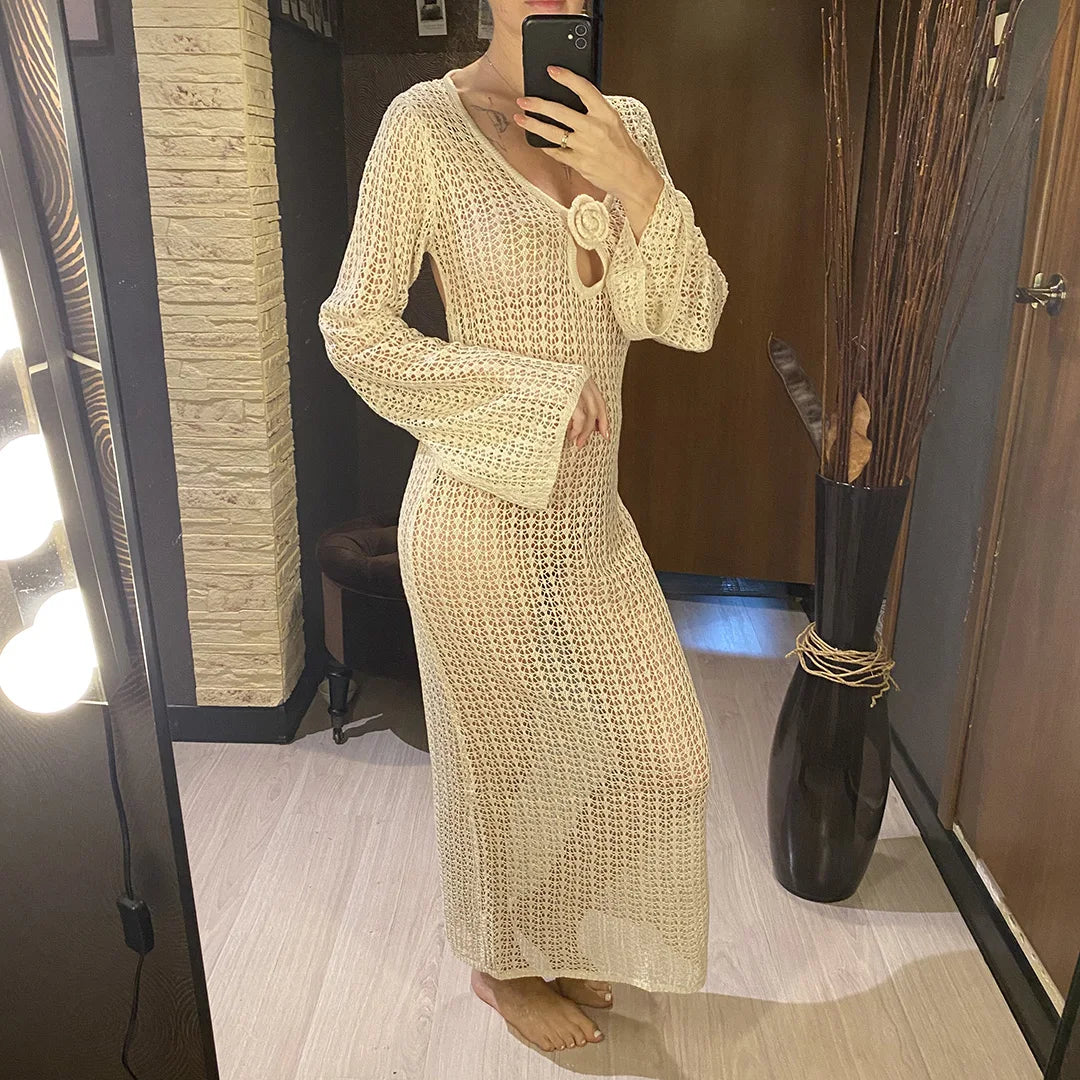 Tunique de plage crochet beige manches longues portée en pied devant un miroir éclairé par des spots, fleur au décolleté