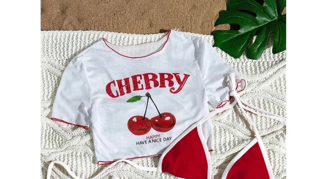 Gros plan sur le haut du maillot trois pièces t-shirt imprimé cerises rouge et blanc