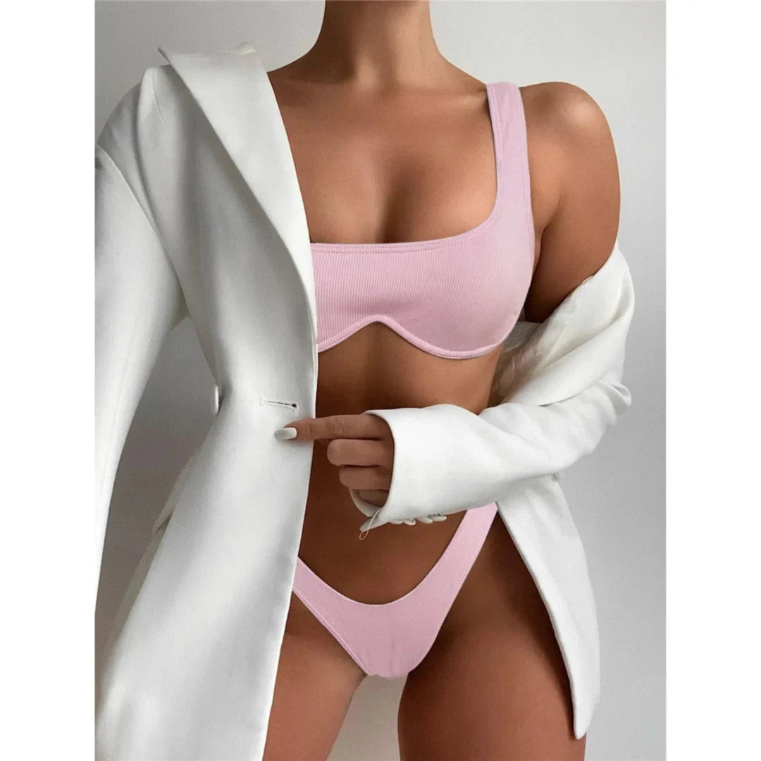 Bikini à armatures brésilien détail en V rose porté de face sous un blazer blanc, bonnets à armatures
