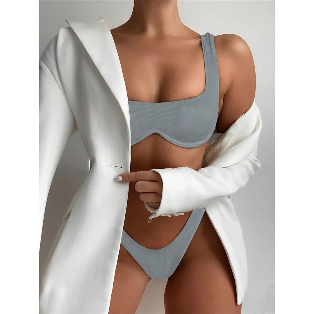 Bikini à armatures brésilien détail en V gris porté de face sous un blazer blanc, bonnets à armatures