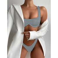 Bikini à armatures brésilien détail en V gris porté de face sous un blazer blanc, bonnets à armatures