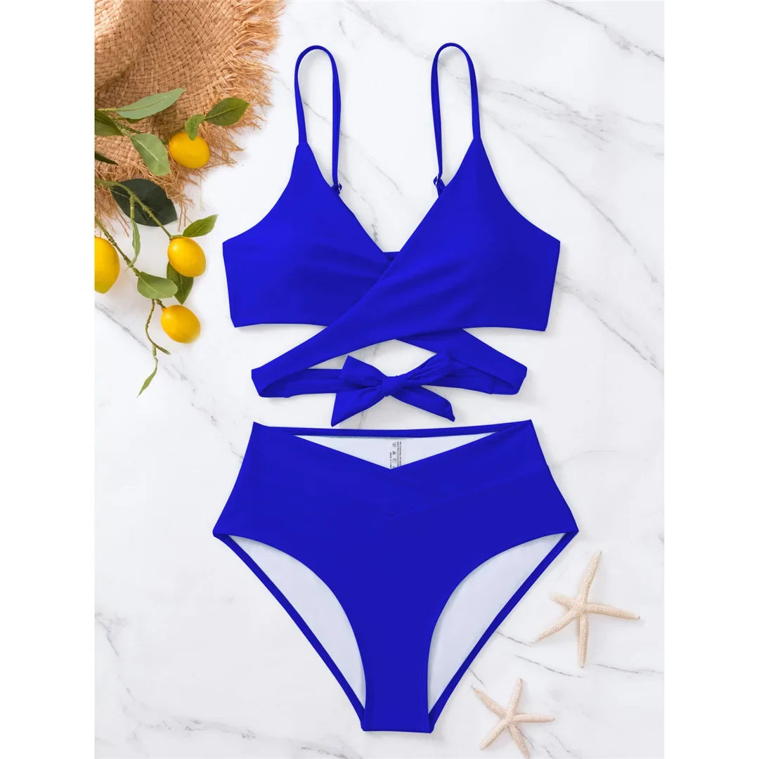 Bikini taille haute bleu roi posé à plat sur marbre, haut croisé autour du buste et culotte taille haute, citrons en décor