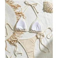 Bikini brésilien tour de cou patchwork à lanières marron clair posé à plat, haut blanc et bas sable