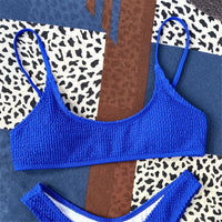Gros plan sur le haut d'un bikini triangle bleu roi effet froissé, bretelles fines et bonnets arrondis