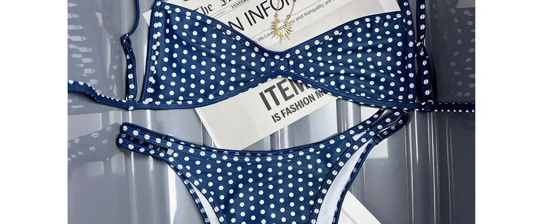 Gros plan sur le haut du bikini bralette taille basse bretelles fines bleu marine à pois blancs