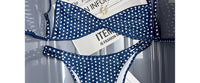 Gros plan sur le haut du bikini bralette taille basse bretelles fines bleu marine à pois blancs