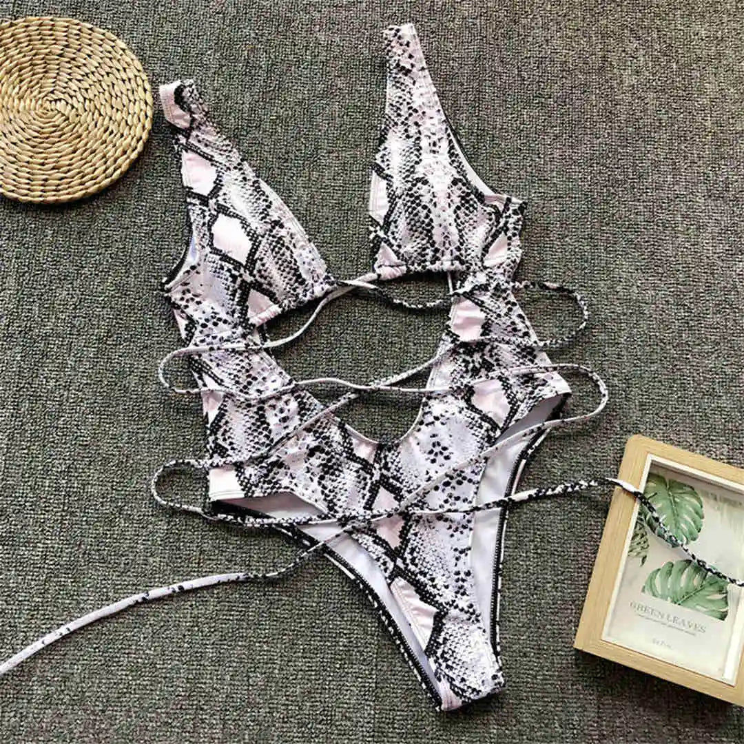 Monokini décolleté plongeant découpe ventre imprimé blanc posé à plat sur tapis, lanières croisées et découpe centrale
