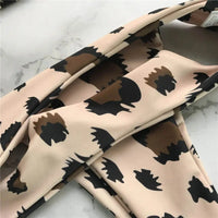 Gros plan sur le tissu à motif léopard beige et brun du bikini sans armatures, avec une bande de bretelle croisée