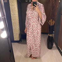 Kimono de plage long ceinturé à imprimé graphique rose mauve, porté en selfie devant un miroir