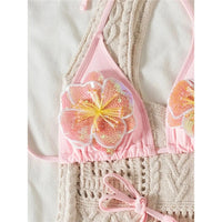 Gros plan sur une fleur en relief rose à paillettes au bonnet d'un bikini, fleur jaune au centre