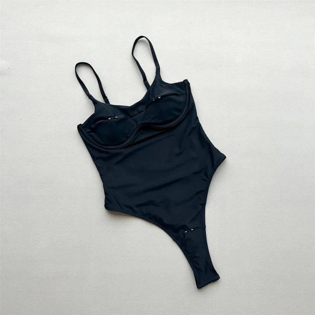 Maillot de bain une pièce échancré à découpes noir vu à plat par l'arrière sur fond clair, bretelles fines réglables