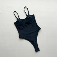Maillot de bain une pièce échancré à découpes noir vu à plat par l'arrière sur fond clair, bretelles fines réglables