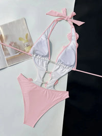 Maillot de bain une pièce décolleté V fleurs 3D rose vu à plat côté doublure blanche, bordure rose et anneau perlé au centre