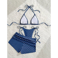 Maillot trois pièces à pois bleu foncé posé à plat, haut à l'intérieur blanc et short à pois fronçé