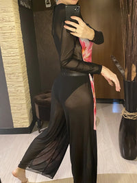Ensemble noir en mesh à manches longues et pantalon large à fleurs roses, vu de côté dans un intérieur