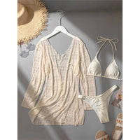 Maillot trois pièces beige posé sur un cintre blanc, cover-up à manches longues, bikini triangle et sandales