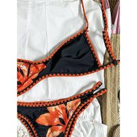 Bikini brésilien triangle imprimé fleuri noir et orange, gros plan sur le haut et la bordure au crochet orange