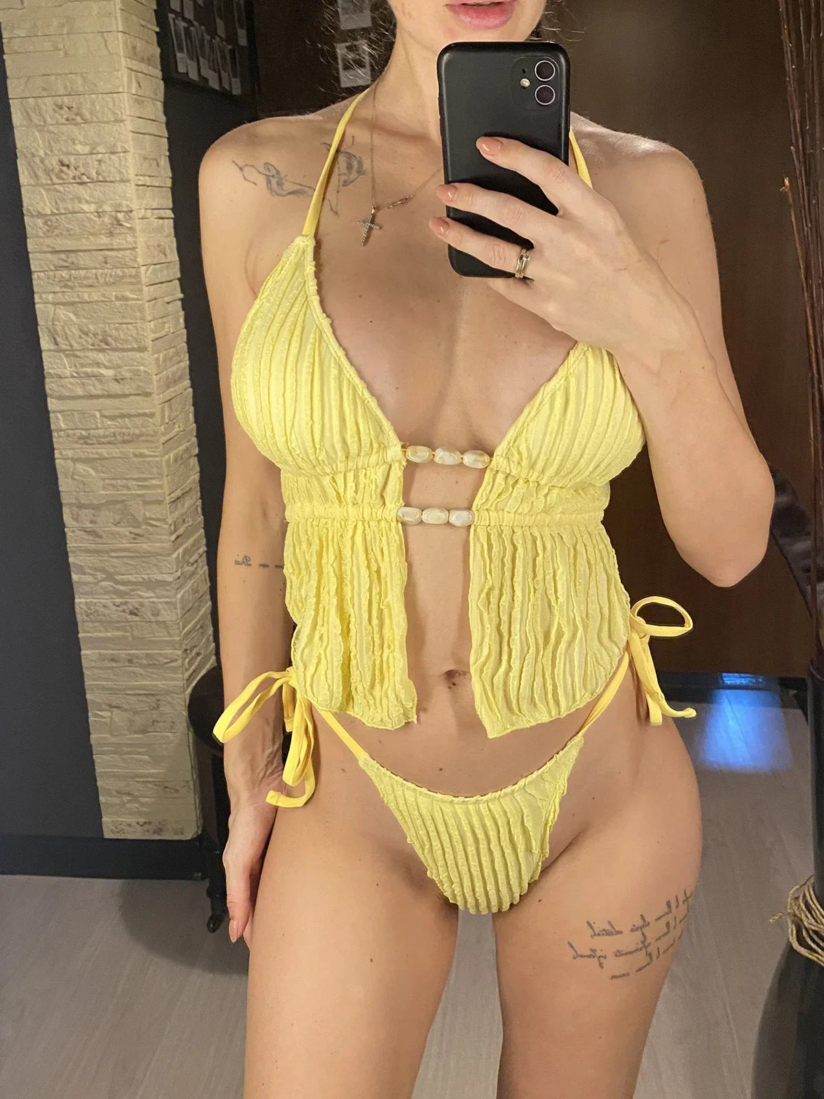 Tankini col halter texturé bas échancré jaune porté de face en selfie, perles coquillage au centre et culotte à liens latéraux