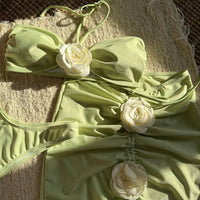 Gros plan sur les fleurs blanches en relief du bustier et de la jupe vert pistache, tissu froncé