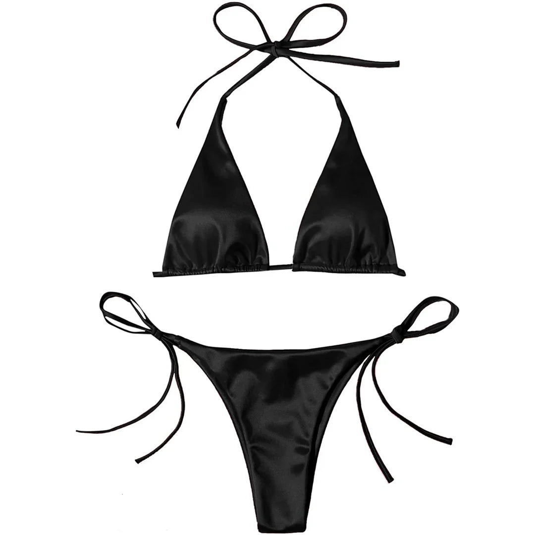 Bikini brésilien satiné noir posé à plat sur fond blanc, haut triangle à bretelles de cou et bas à fins lacets