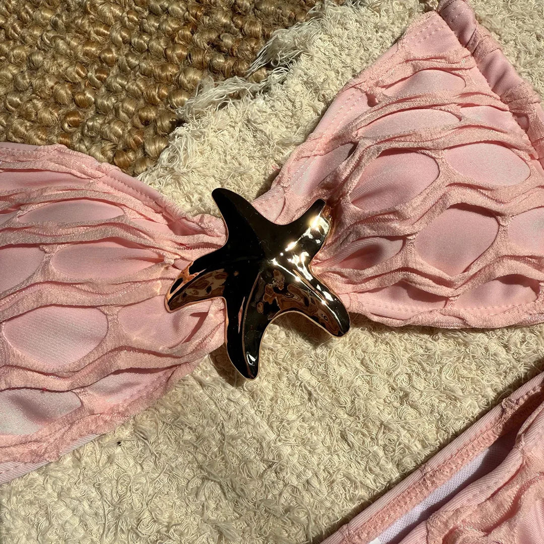 Gros plan sur l'étoile métal du bikini beige rosé échancré, bonnet ondulé en relief et lanières fines