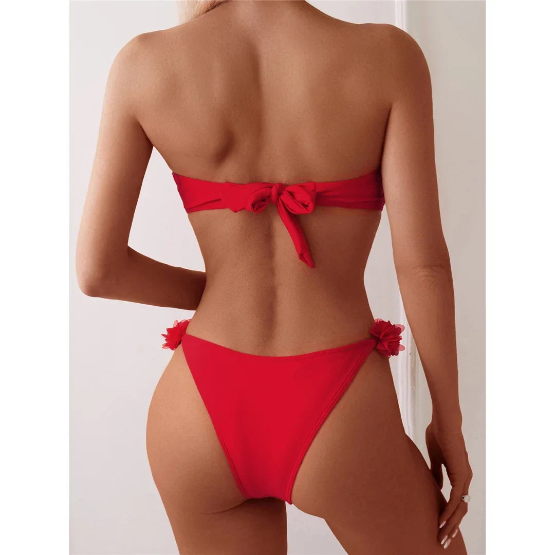 Bikini bandeau à fleurs en relief rouge vu de dos, nœud au centre du bandeau et fleurs fixées sur les côtés du bas
