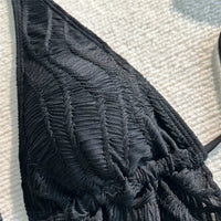 Gros plan sur le haut texturé du maillot de bain trois pièces noir, motif en relief et col halter
