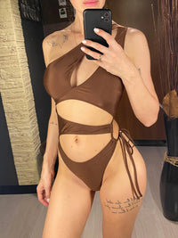Maillot de bain une pièce asymétrique marron avec anneau doré et lien latéral, porté de face en selfie au miroir