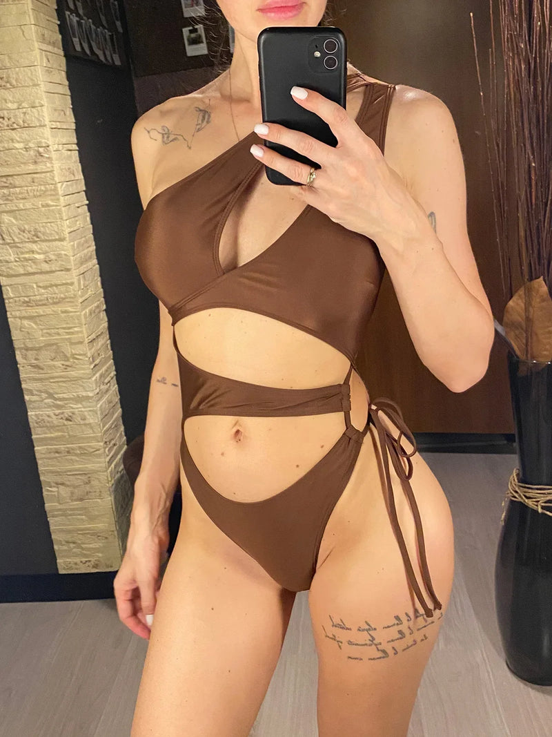 Maillot de bain une pièce asymétrique marron avec anneau doré et lien latéral, porté de face en selfie au miroir
