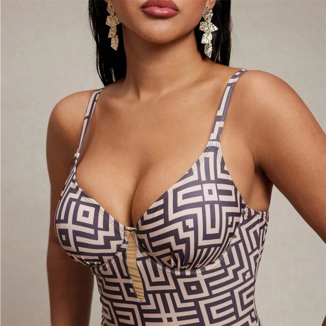 Gros plan sur le décolleté V imprimé marron d'un maillot une pièce, anneau doré au centre et bretelles fines